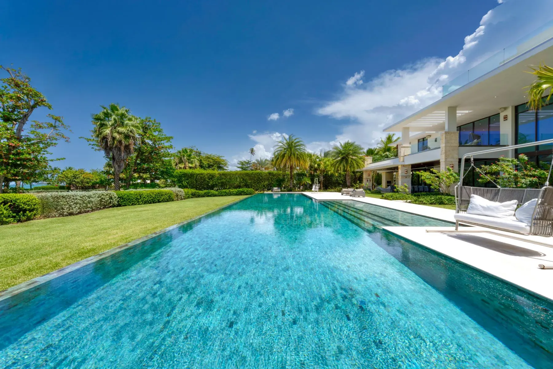 Infinity pool doing that mirror thing. Whole house gleaming behind it.