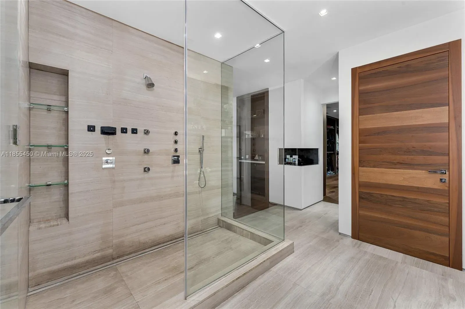 Then a lighter bath—glass walk-in, big beige tiles, very minimal.