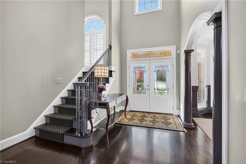 Tall ceiling right at the door. Gray walls, dark floors, nice first impression.