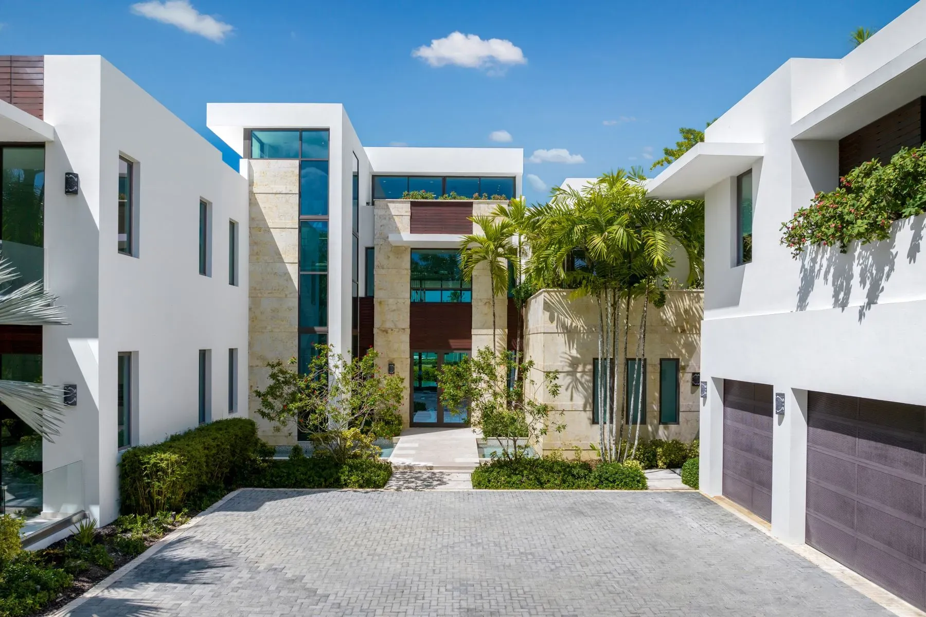 Front shot. white walls with stone strips, huge panes everywhere.