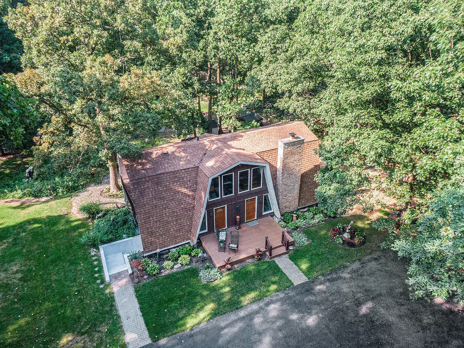 A-frame exterior with reddish shingles. cozy-meets-modern, and that roofline is dramatic.