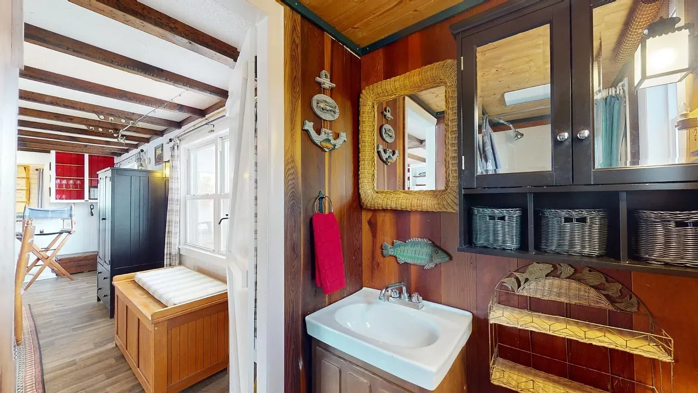 Hallway is all wood paneling and beams. Cozy cabin walkway vibes.