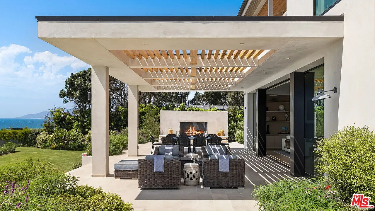Shaded lounge under a clean-lined pergola. Slats throw those nice stripes of light.