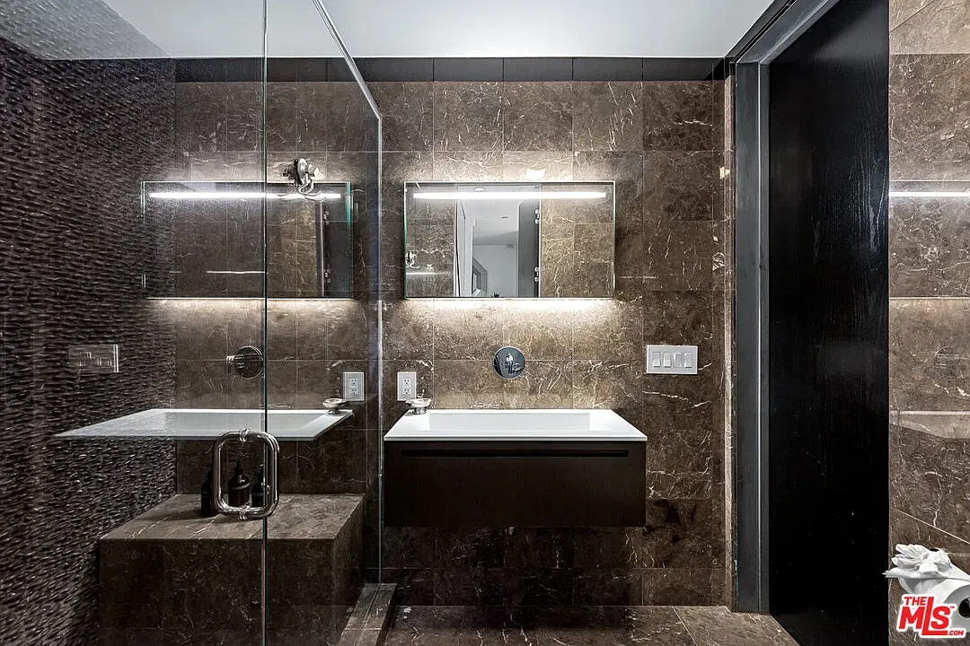 Dark tile walls, light marble floors. Spa mood without trying too hard.