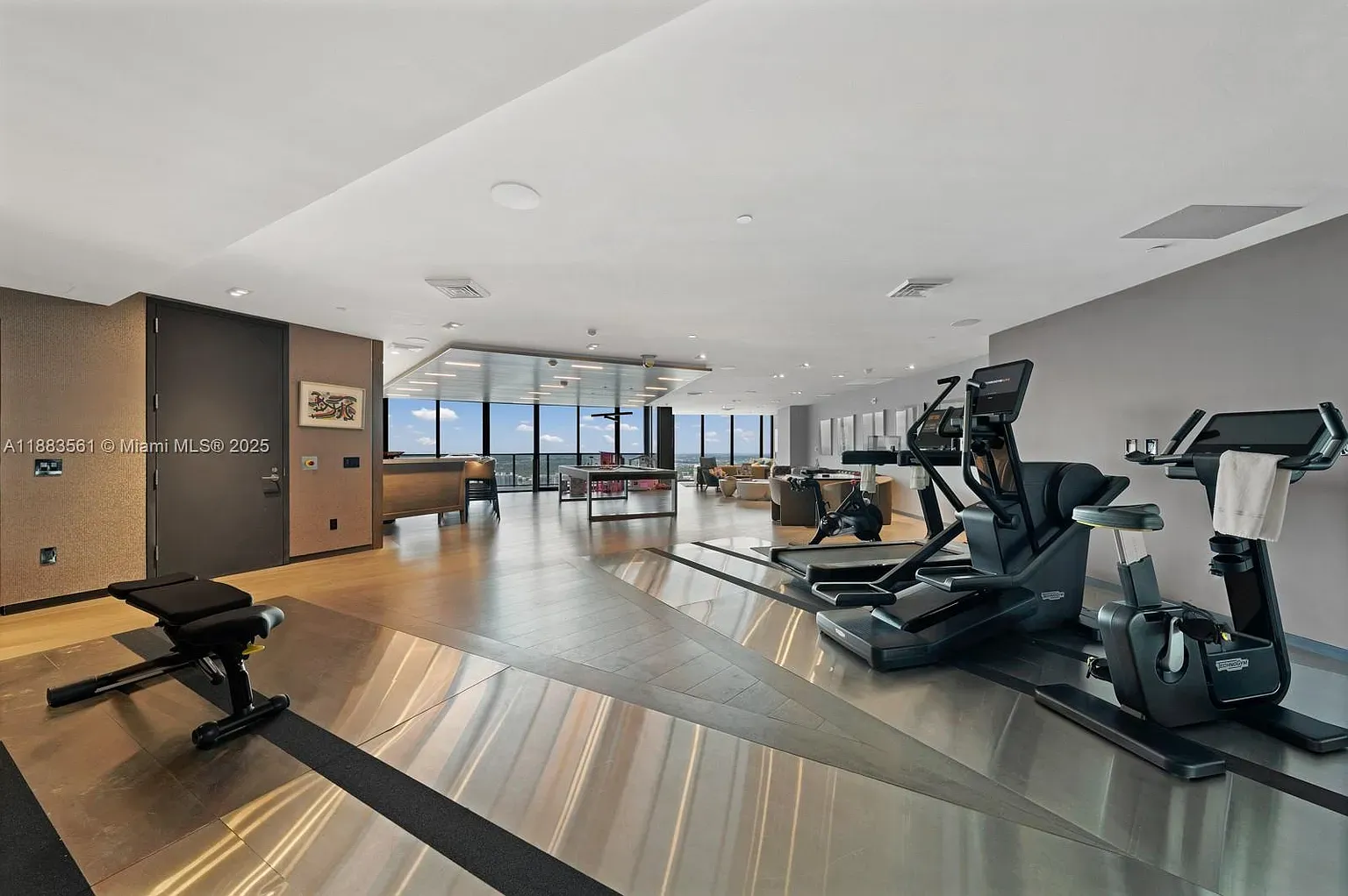 Gym with skyline views? Okay, motivation unlocked. Muted tones, equipment doesn’t scream.