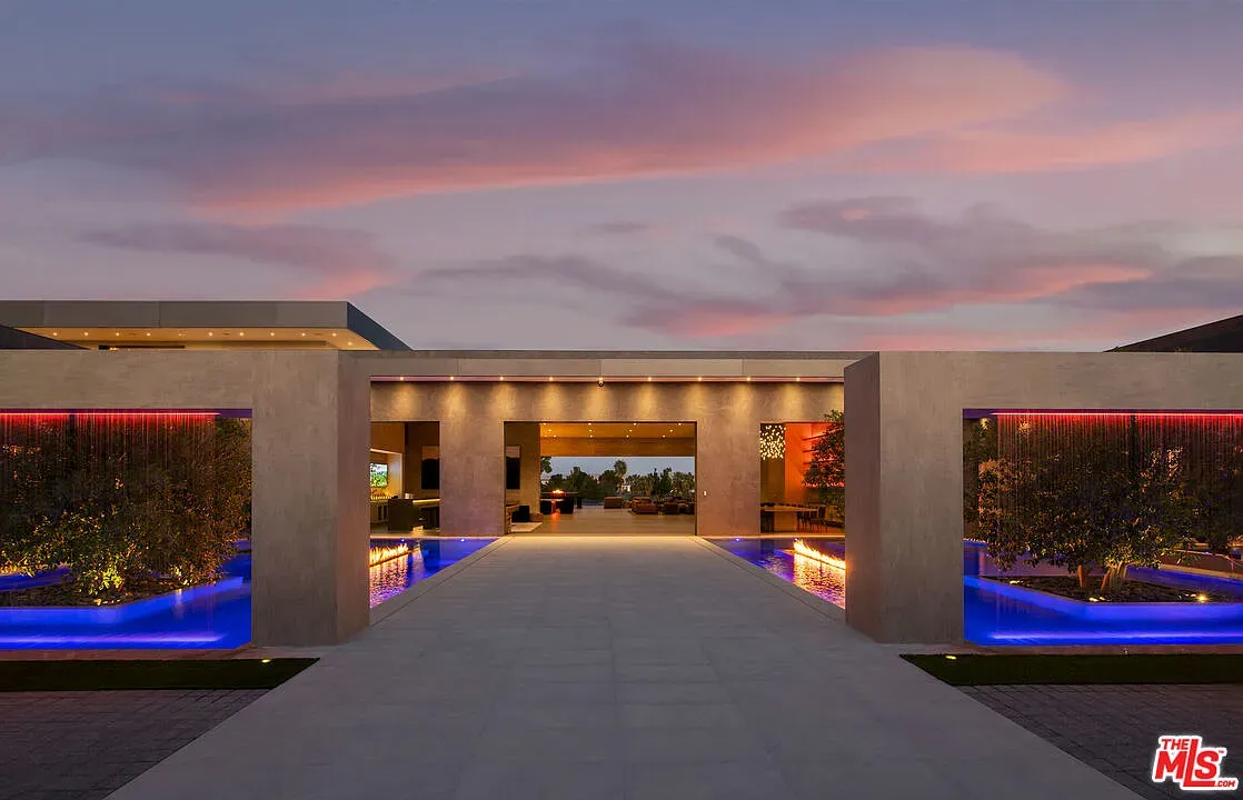 Twilight courtyard shot—modern lines, palms, everything glowing a resort ad.