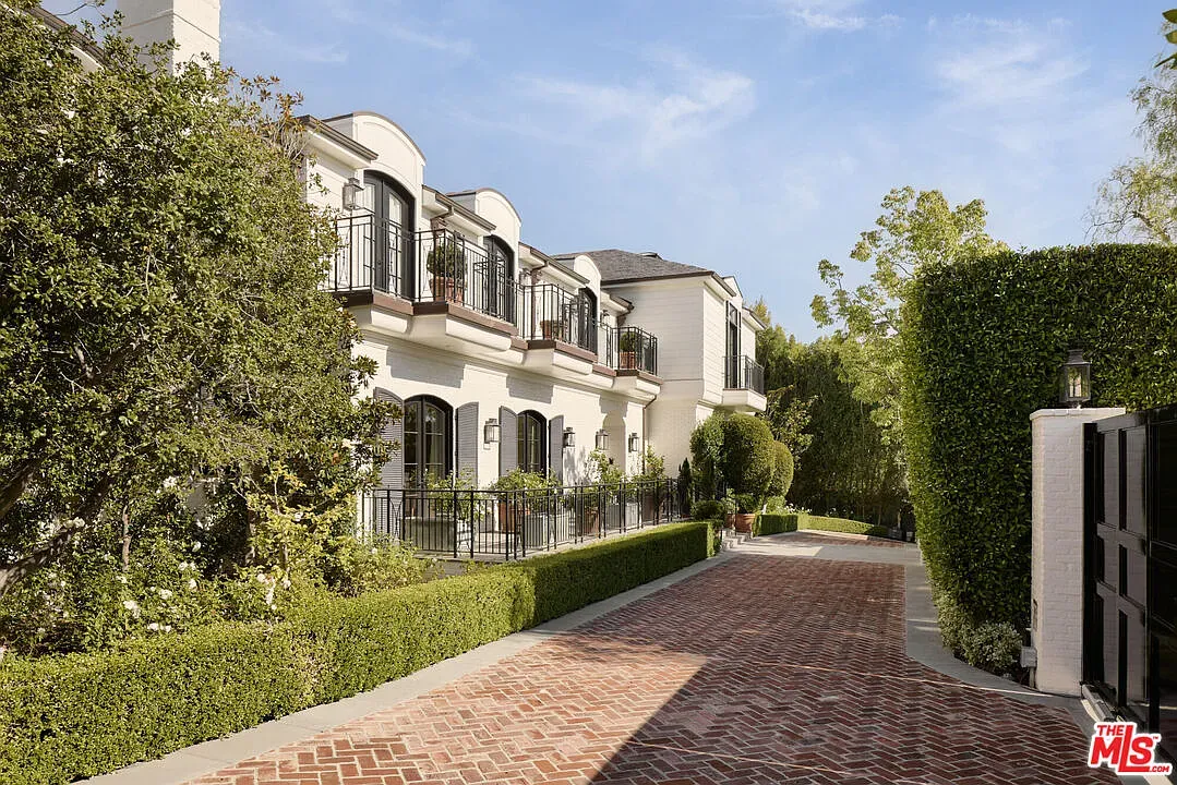 This angle shows the arched windows. Cream brick and brick path feel timeless.