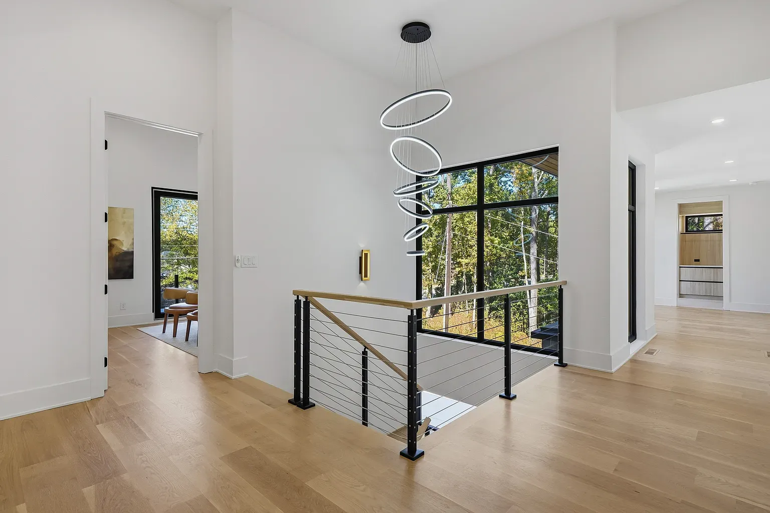Hallway is simple and bright. Honey floors keep it from feeling sterile.