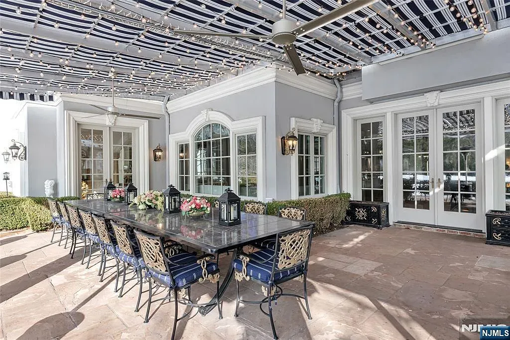 Outdoor dining with granite table and navy cushions. Classy dinner party energy.