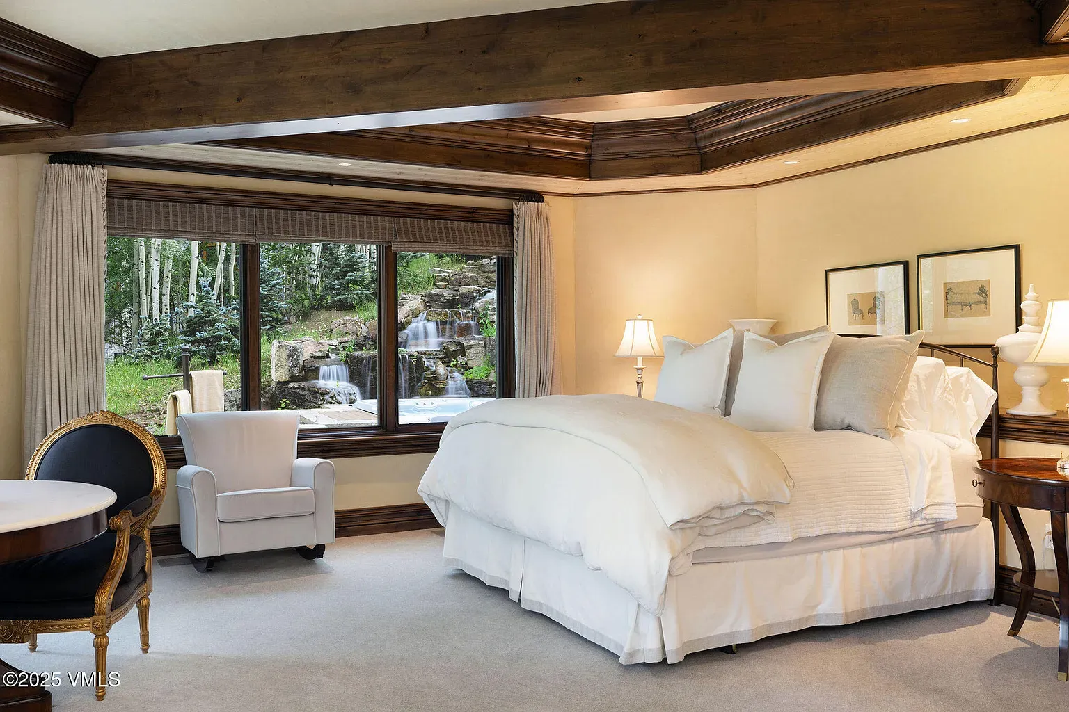 Coffered ceiling moment. Warm wood, fluffy bedding. Looks hotel-level cozy.