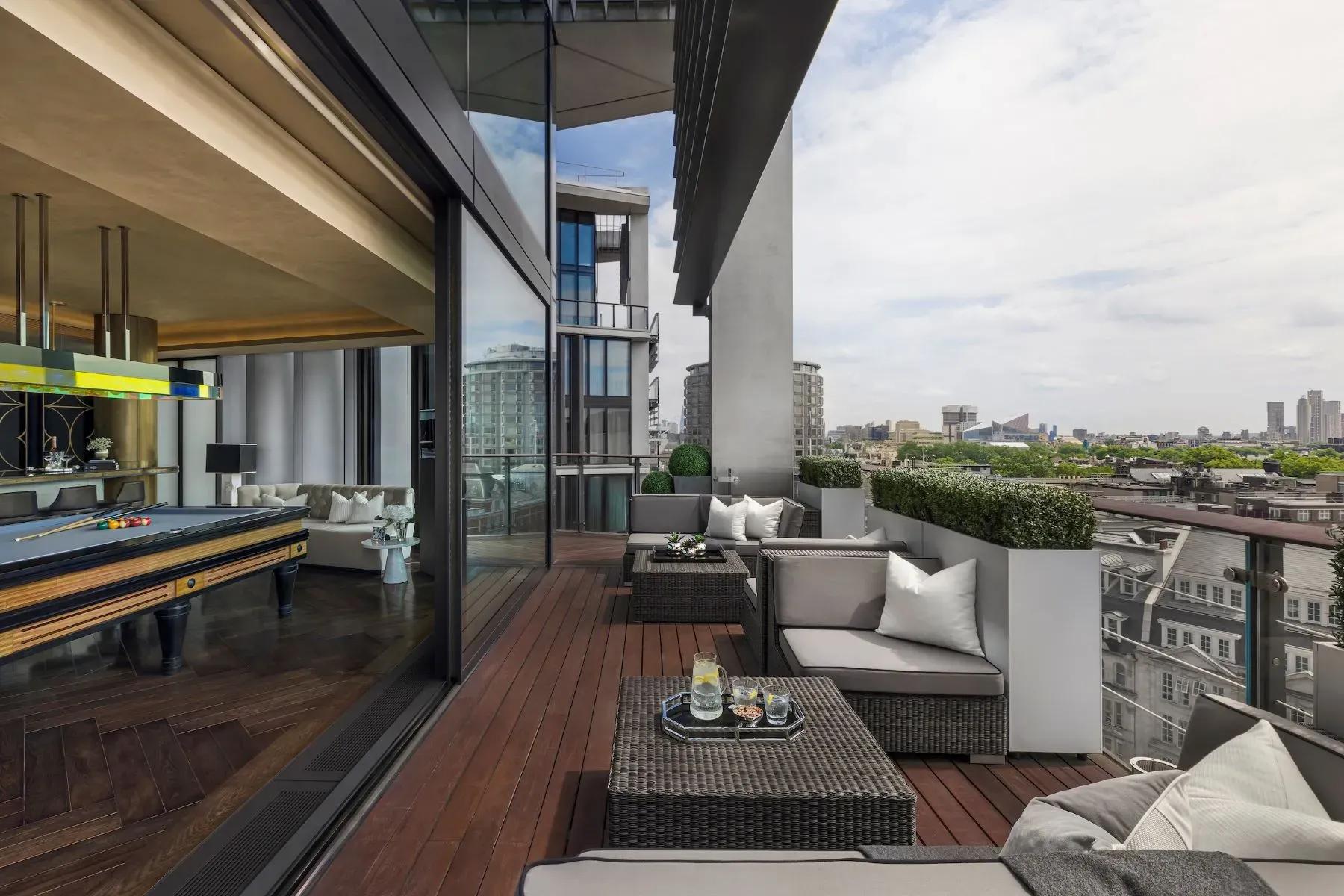Dark wood deck, big gray sofas, city backdrop. Yeah, I’d sit here.