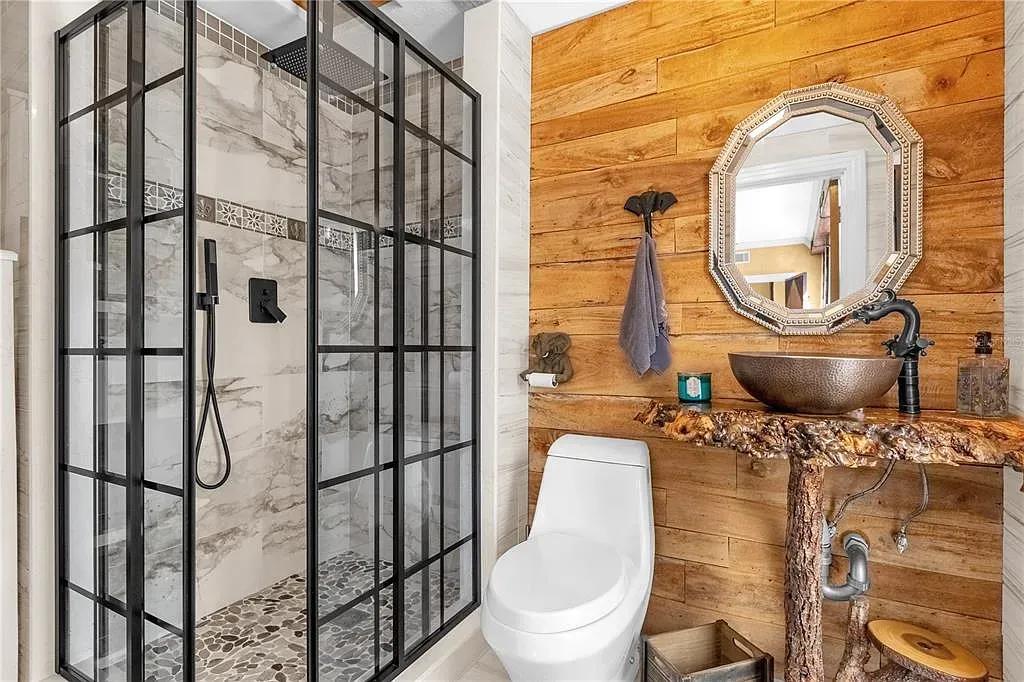 Black-framed shower with marble veining. Clean, modern, and kind of luxe hotel energy.
