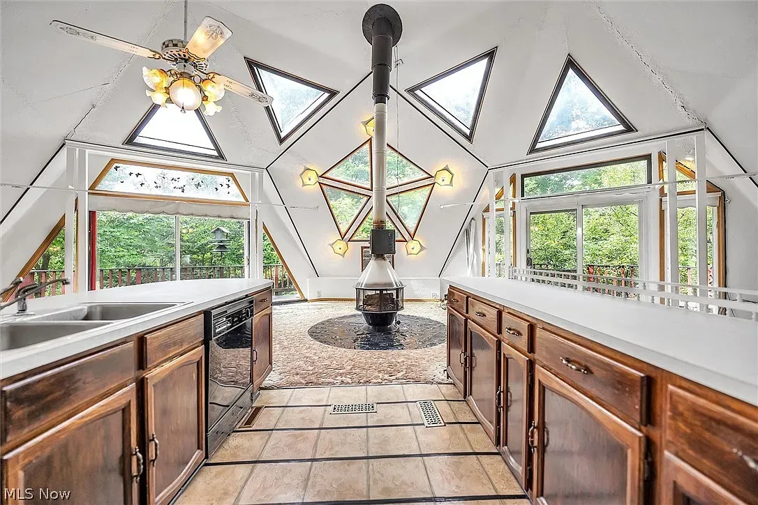 A-frame kitchen corner. light wood cabinets, white counters, big forest views.