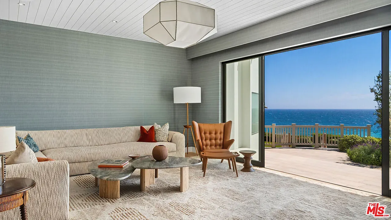 Living room keeps it soft and neutral. Huge couch, ocean view doing the work.