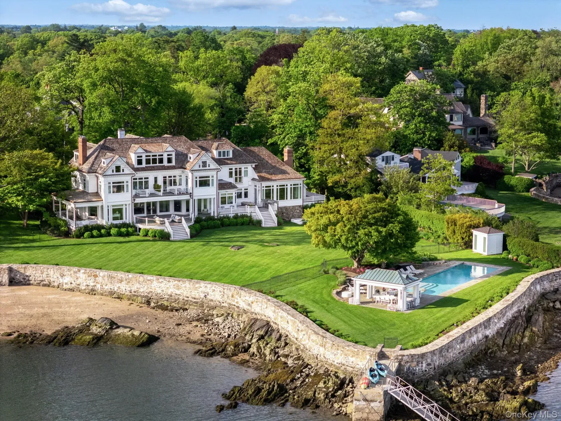 Big white clapboard by the water. Those windows and wraparound deck go hard.
