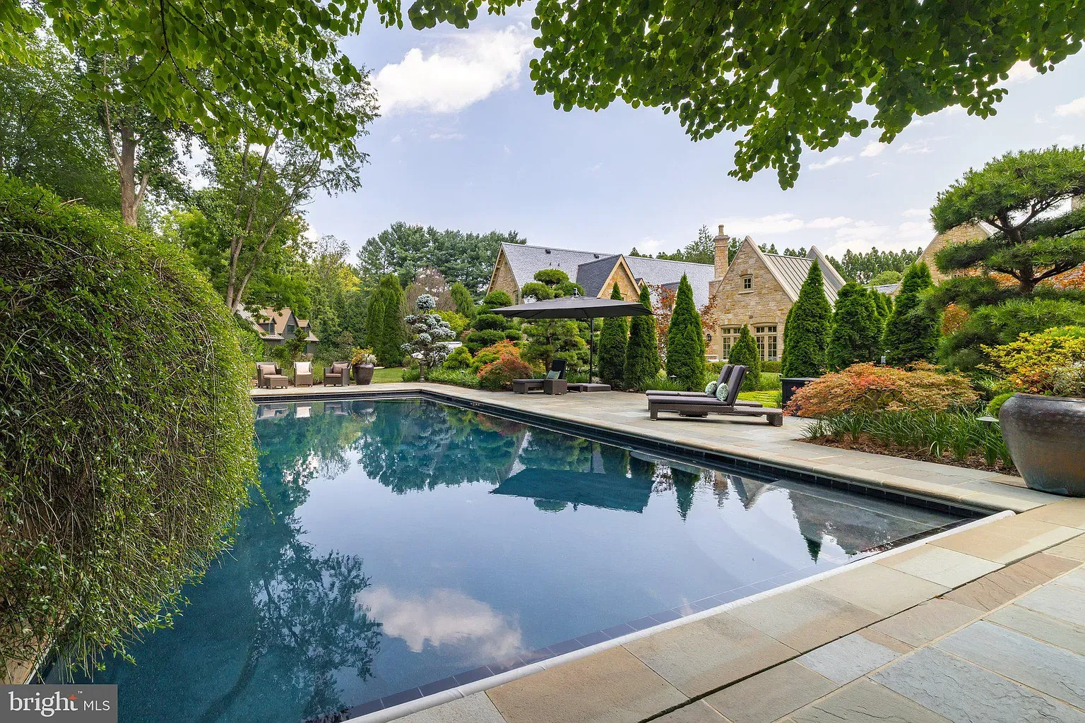 Pool shot from the side—blue glassy water, tidy stone edges.