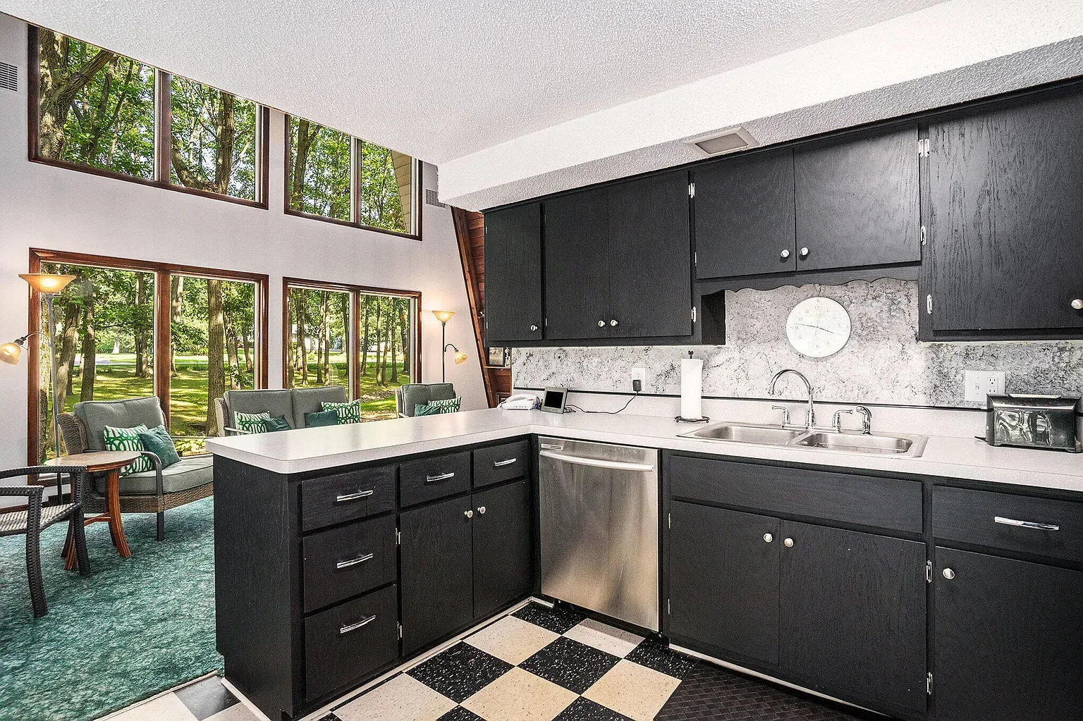 Matte black cabinets, white counters, and a quiet stainless dishwasher flex.