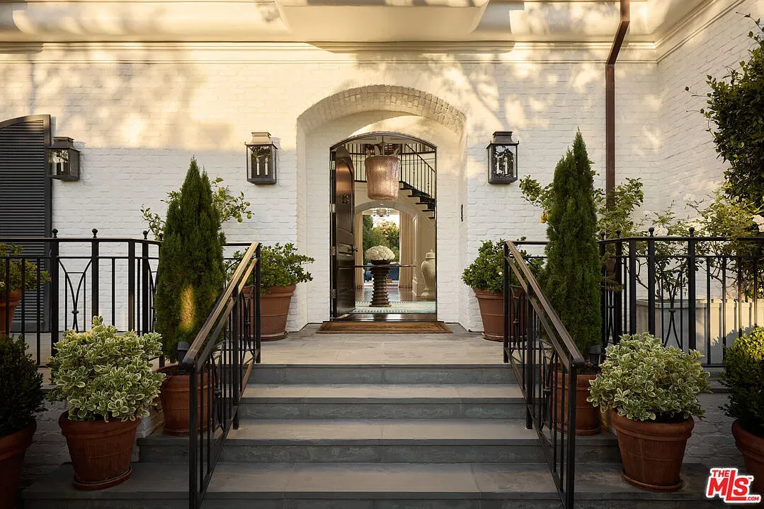 Front steps with planters feel fancy. White brick looks crisp.