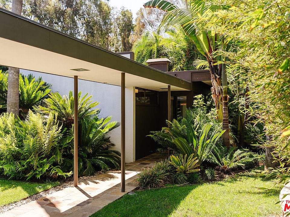 Stone path to that sharp roofline. White and dark wood playing nice.