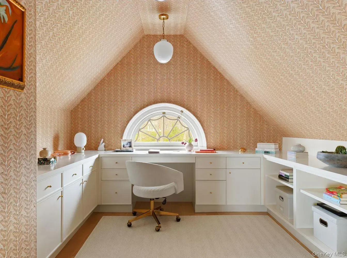 Attic desk under the circle window. Peach wallpaper is weirdly cute.