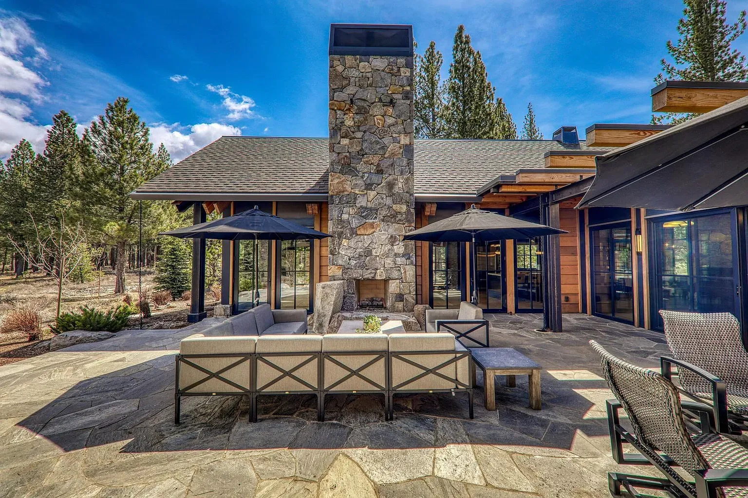 Patio hangout with a massive stone fireplace. Trees everywhere. Bring a sweater.