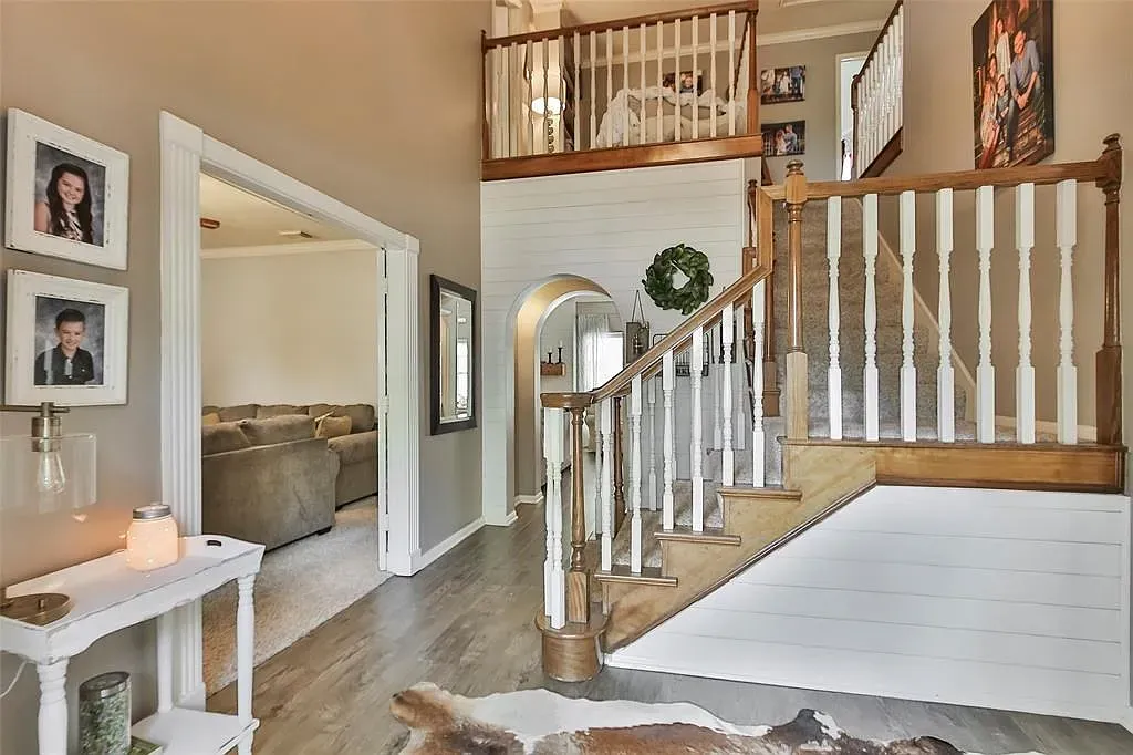 Curved wood staircase moment. Kinda grand, but warm enough to feel homey.