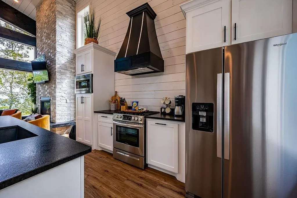 White cabinets, dark granite, big stainless hood. Yes, that gas range means business.