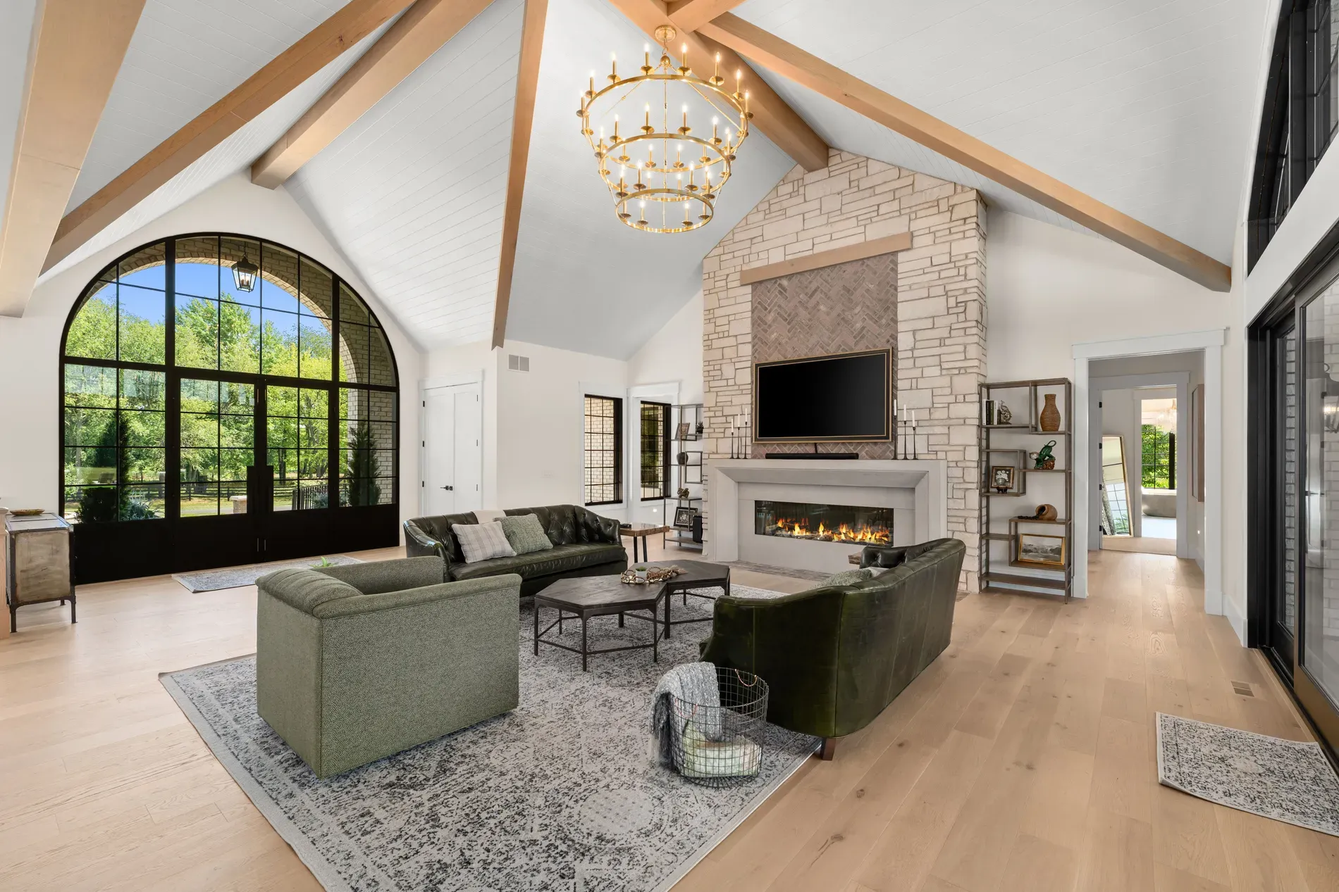 Living room goes tall. big beams, white shiplap, sunlight doing its thing.