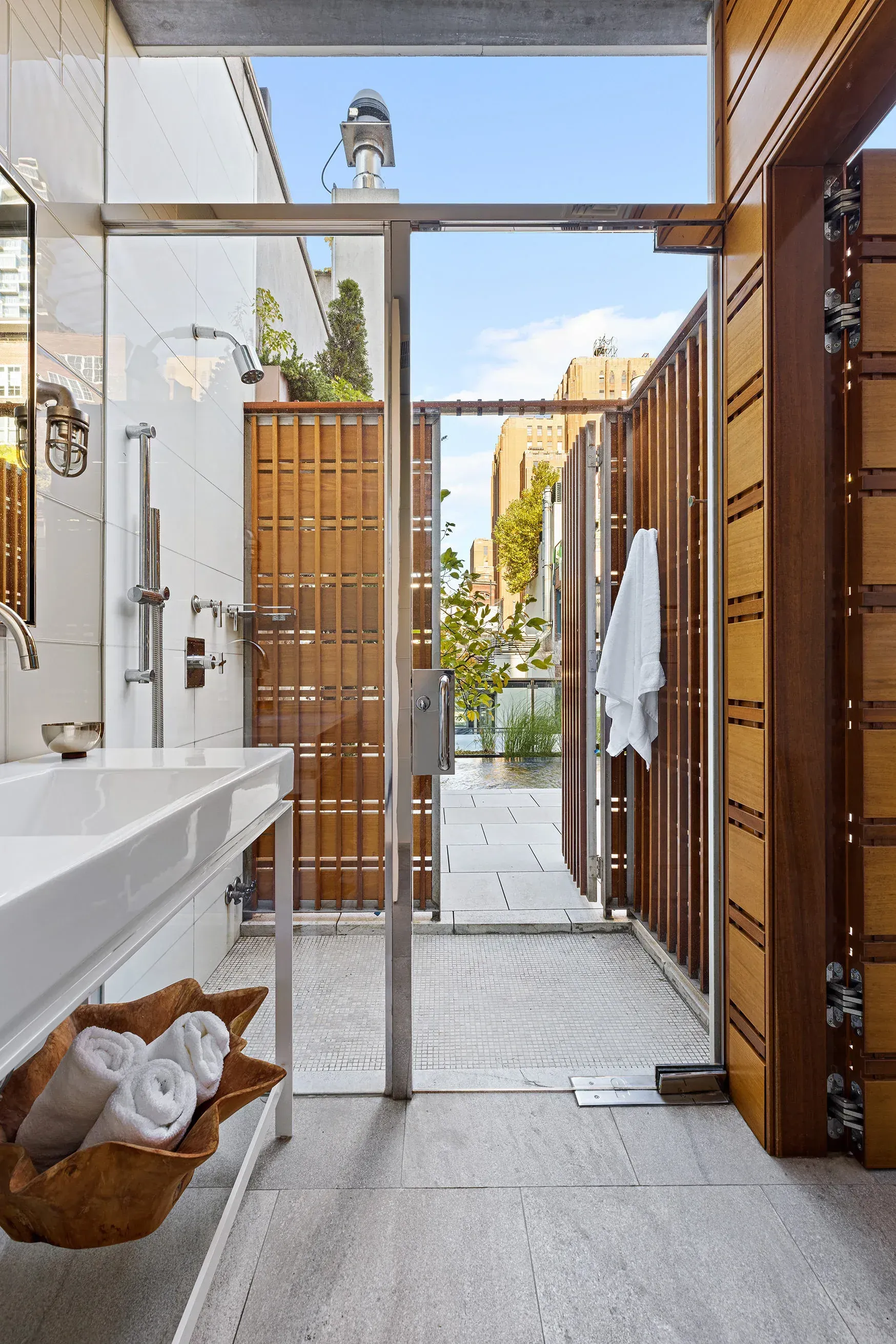 Outdoor bath in gray stone. Freestanding tub chilling under the sky—anyone know why?