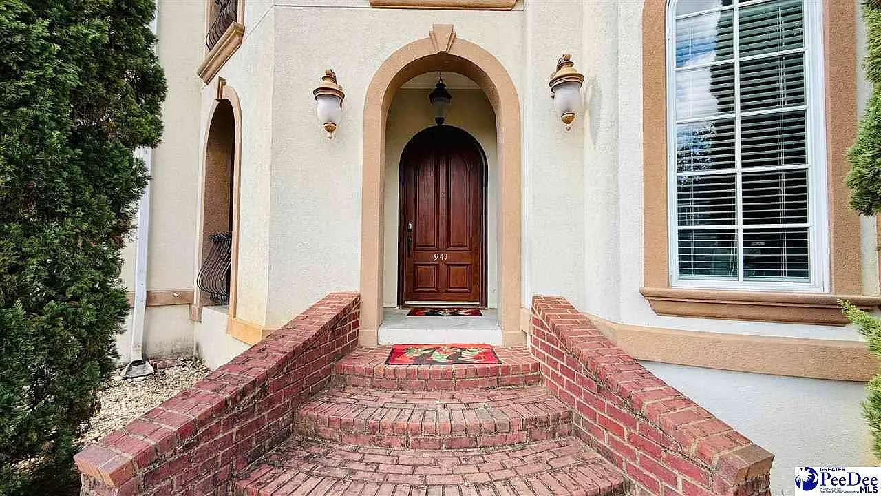 That arched wood door is doing all the welcoming.