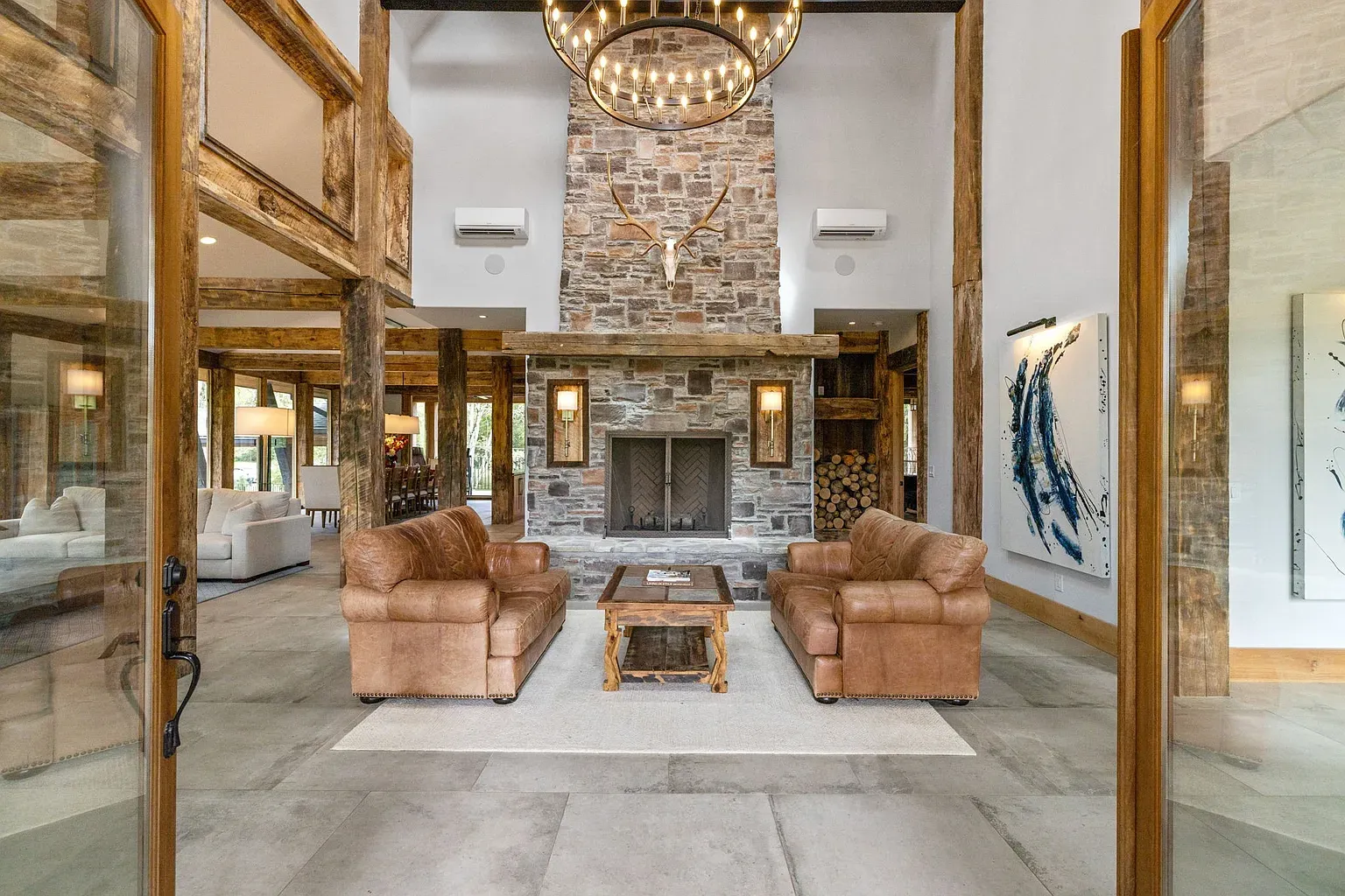 Giant stone fireplace plus an antler chandelier that definitely has stories.