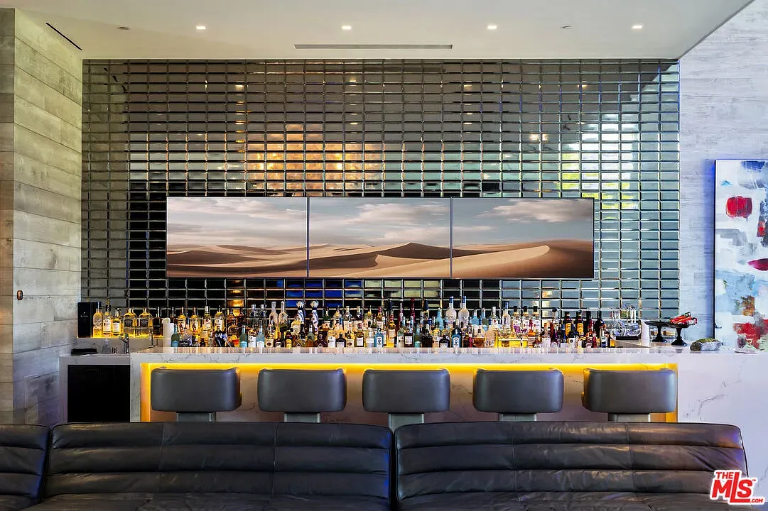 That metallic tile wall behind the bar is doing all the talking.