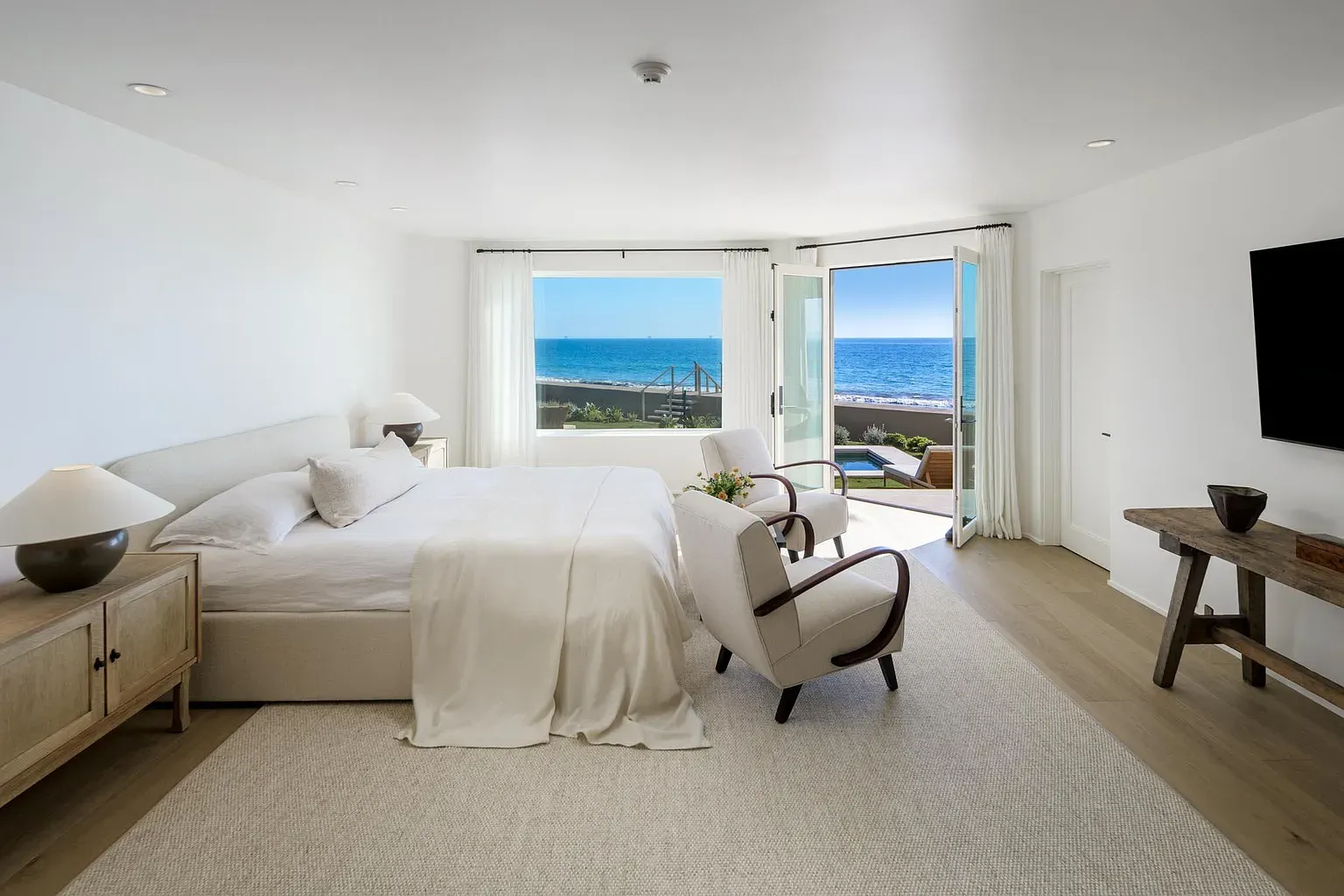 Another bedroom pointed straight at the water. Soft linens, windows doing the heavy lifting.