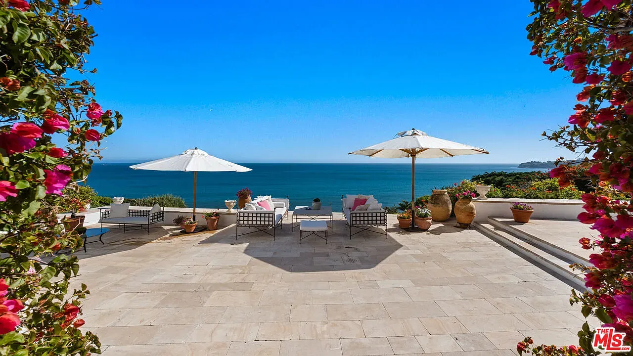 Here's the terrace — ocean framed by bougainvillea. Glow-y stone patio. Dreamy.