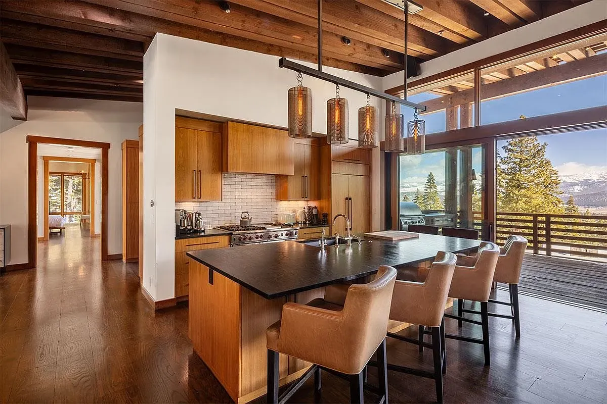 Kitchen island with dark granite, honey cabinets, comfy stools. Simple, solid, everyday nice.
