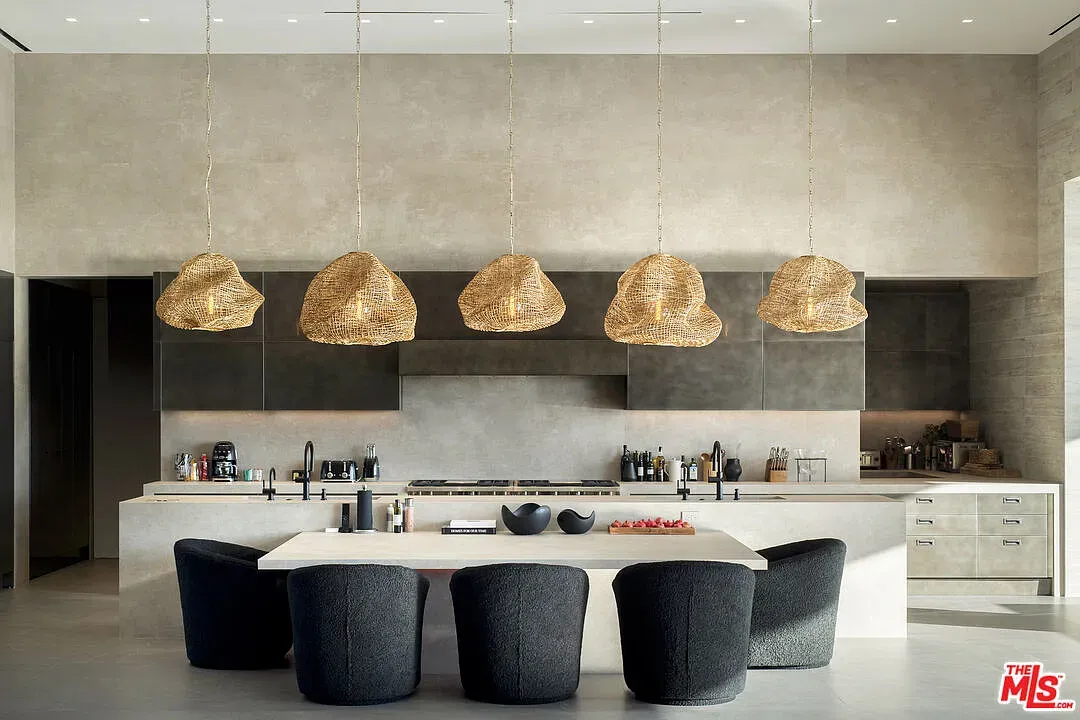 Minimal kitchen—concrete feature wall, huge island, everything looks sharp and expensive.