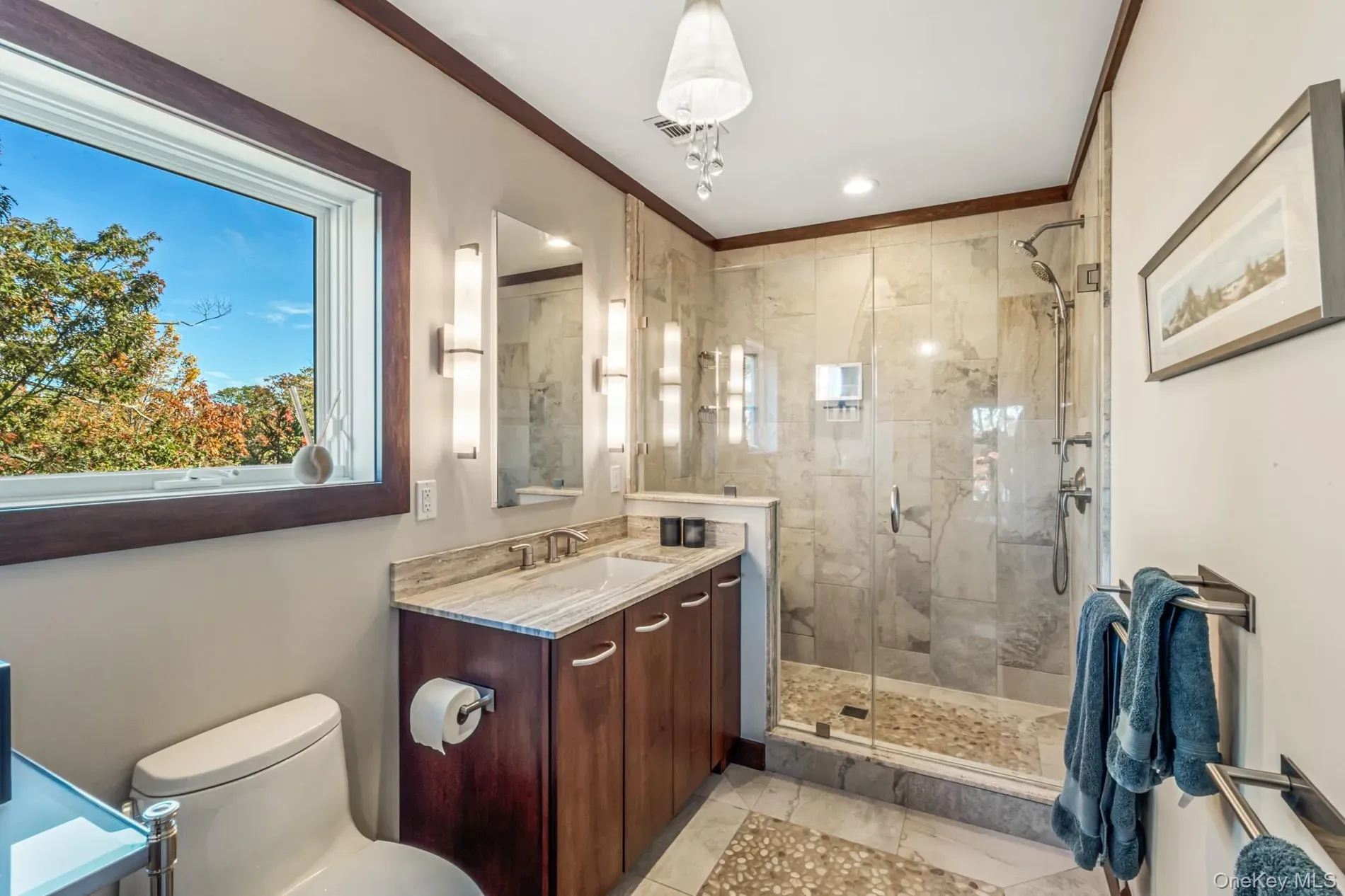 Double vanity with dark wood. calm colors, looks spa-level clean.