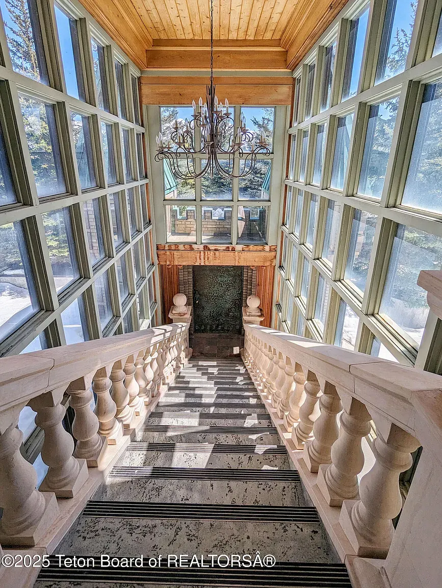 Grand staircase moment—carved rails, tons of windows, sunlight everywhere.