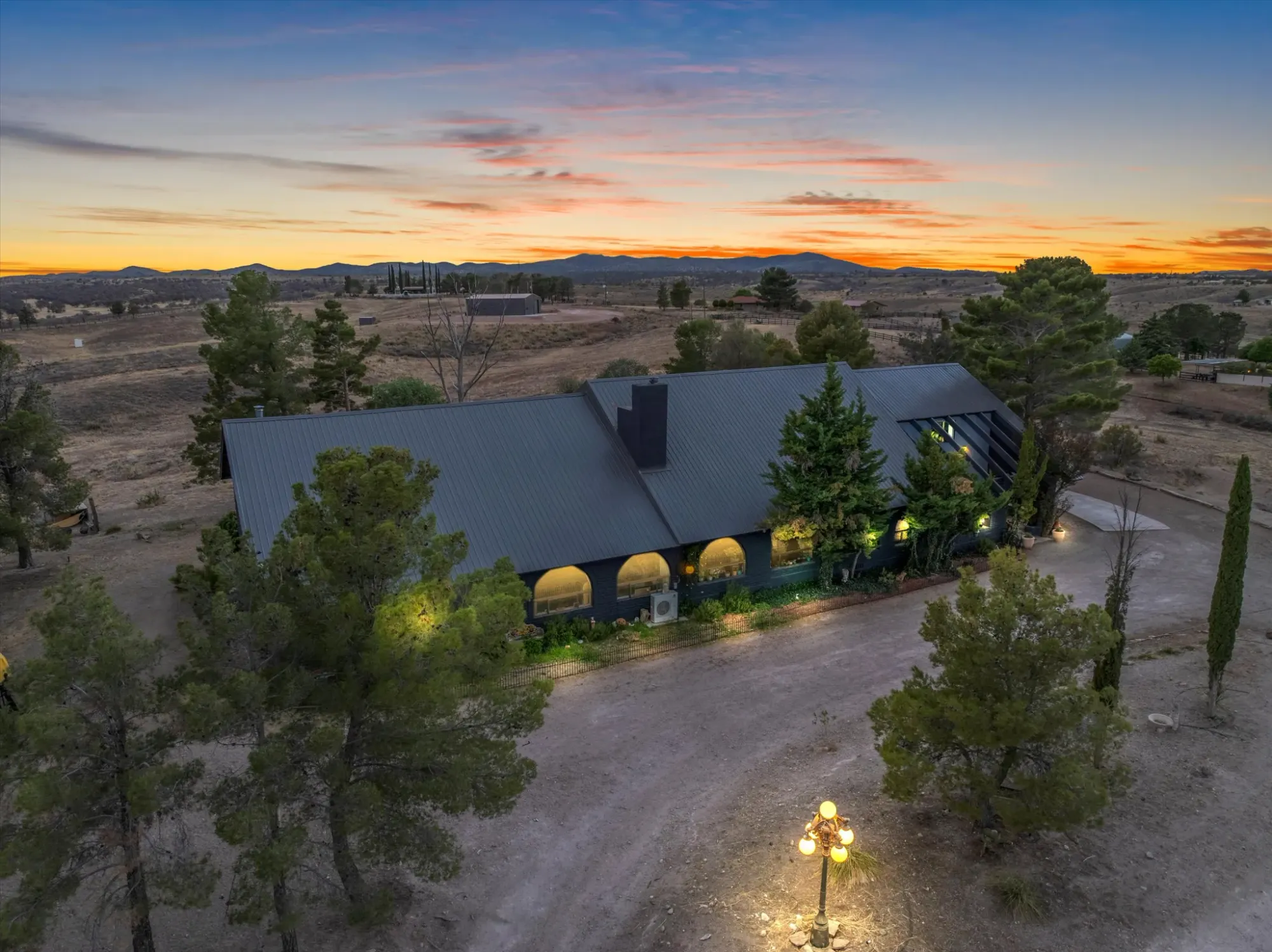 Modern farmhouse vibes with that dark metal roof and a lot of sky.