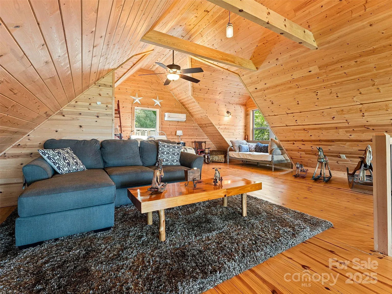 Loft room with honey wood and beams. Throw a couch here and hibernate.
