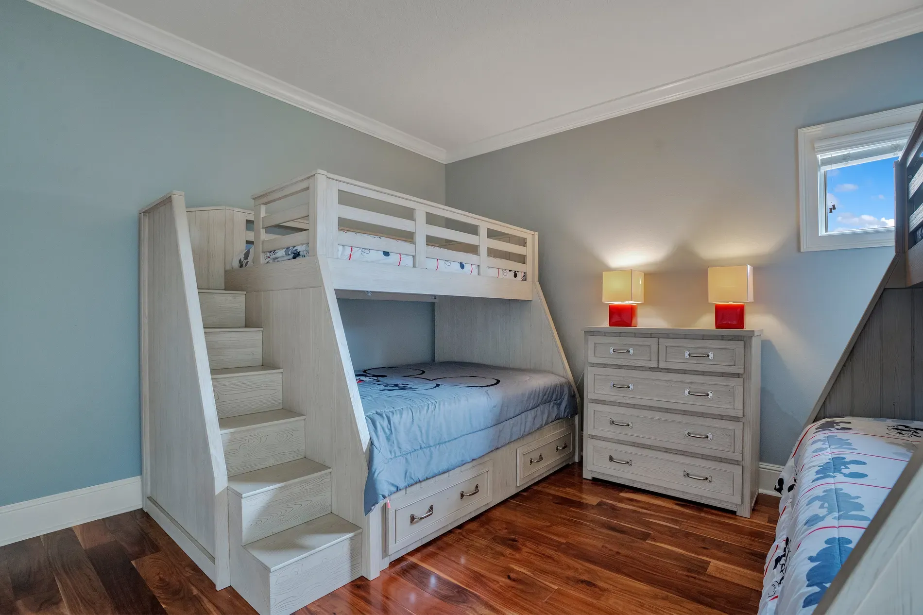 Kids’ bunk room in beachy blue. Light wood bunks look sturdy and cute.