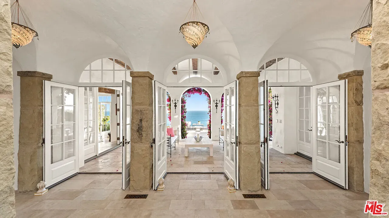 Here's the entry — vaulted, pendant lights, ocean peeking straight through. Big statement.