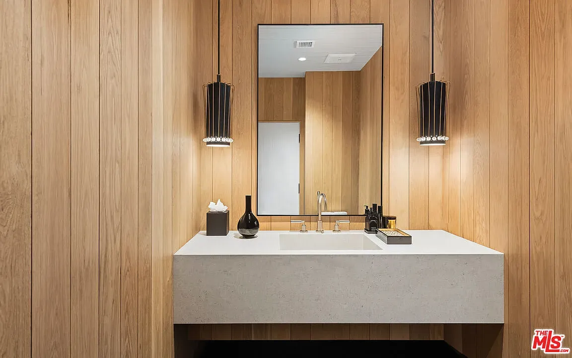 Wood-paneled bath with crisp white counter. Warm without feeling heavy.