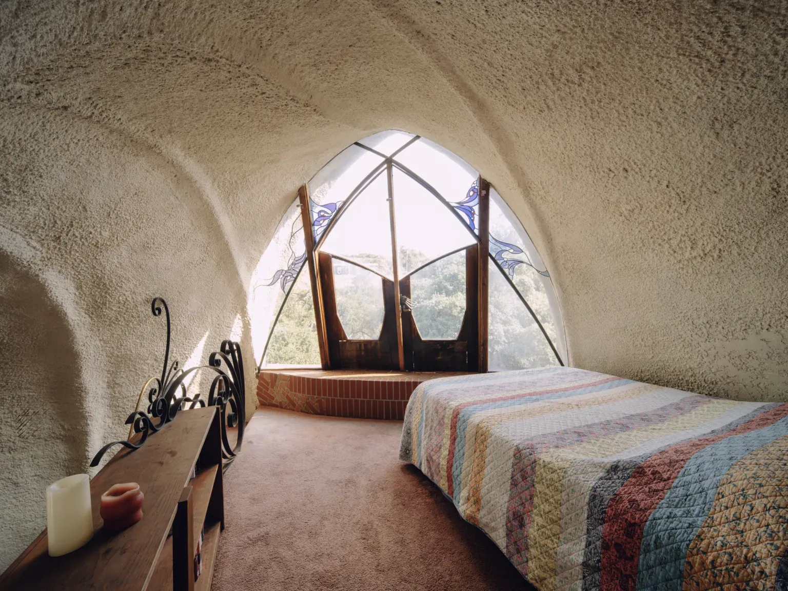 Bedroom dome ceiling, plastered and soft. Feels quiet and cave-like.