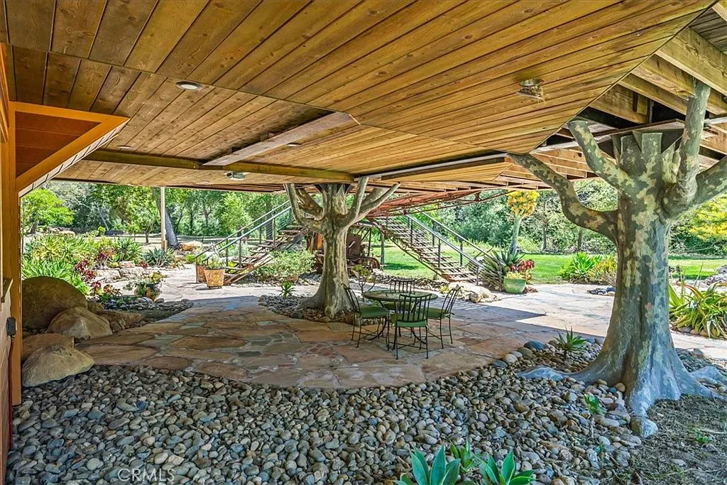Patio under that big wood overhang. Stone and pebbles look great together.