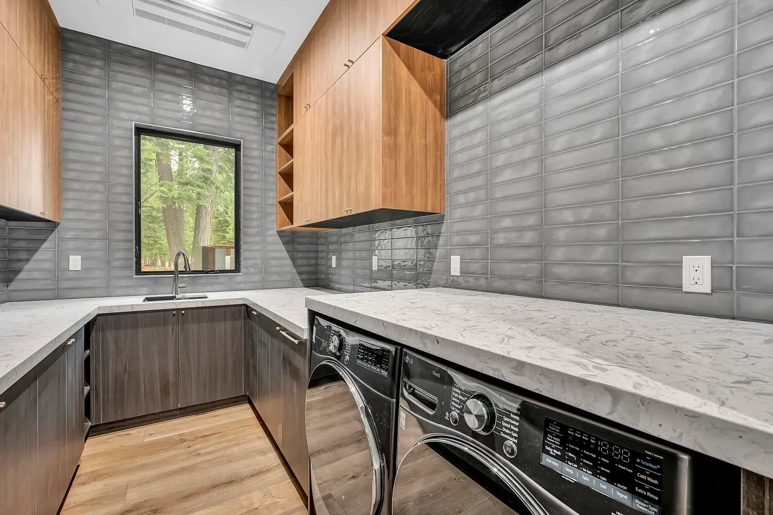 Even the laundry got the spa treatment. Dark cabinets, glossy tile everywhere.