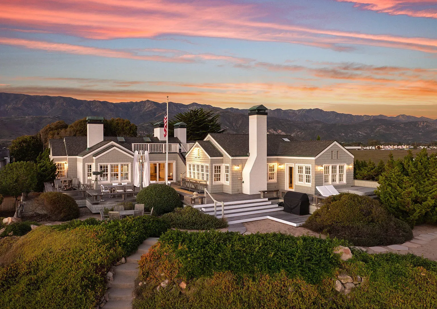 Classic coastal cottage front—white siding, slate roof, tidy symmetry.