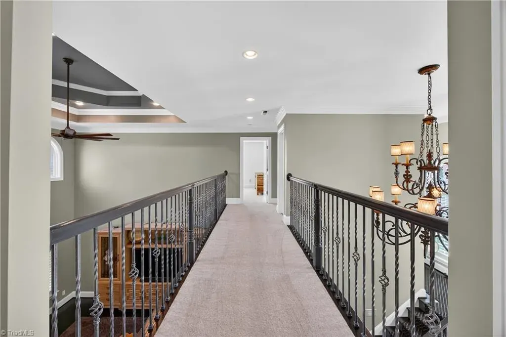 Hallway is bright and quiet. Soft carpet, everything painted that safe gray.