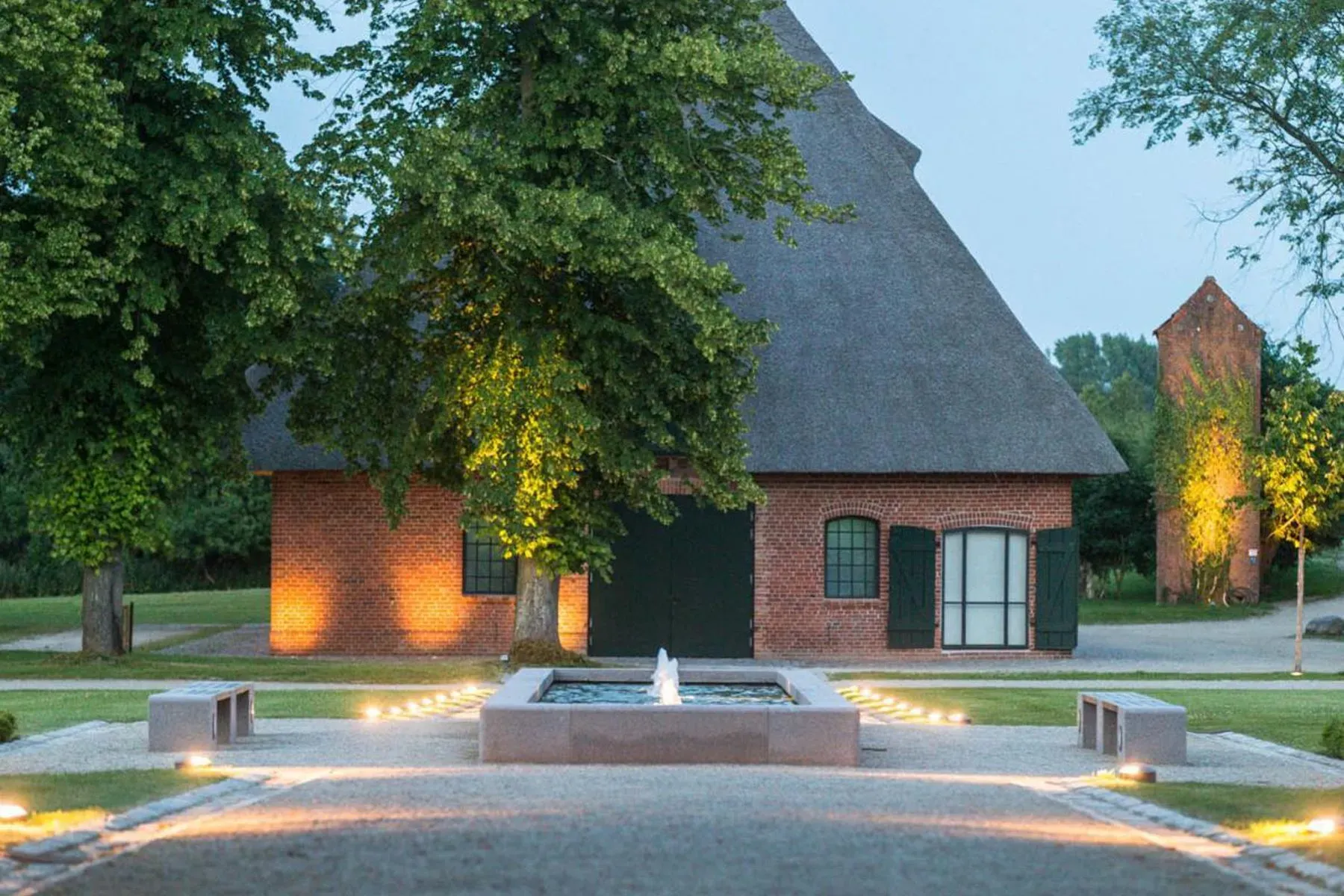Storybook brick with a thatched roof peak. Green arched door seals it.