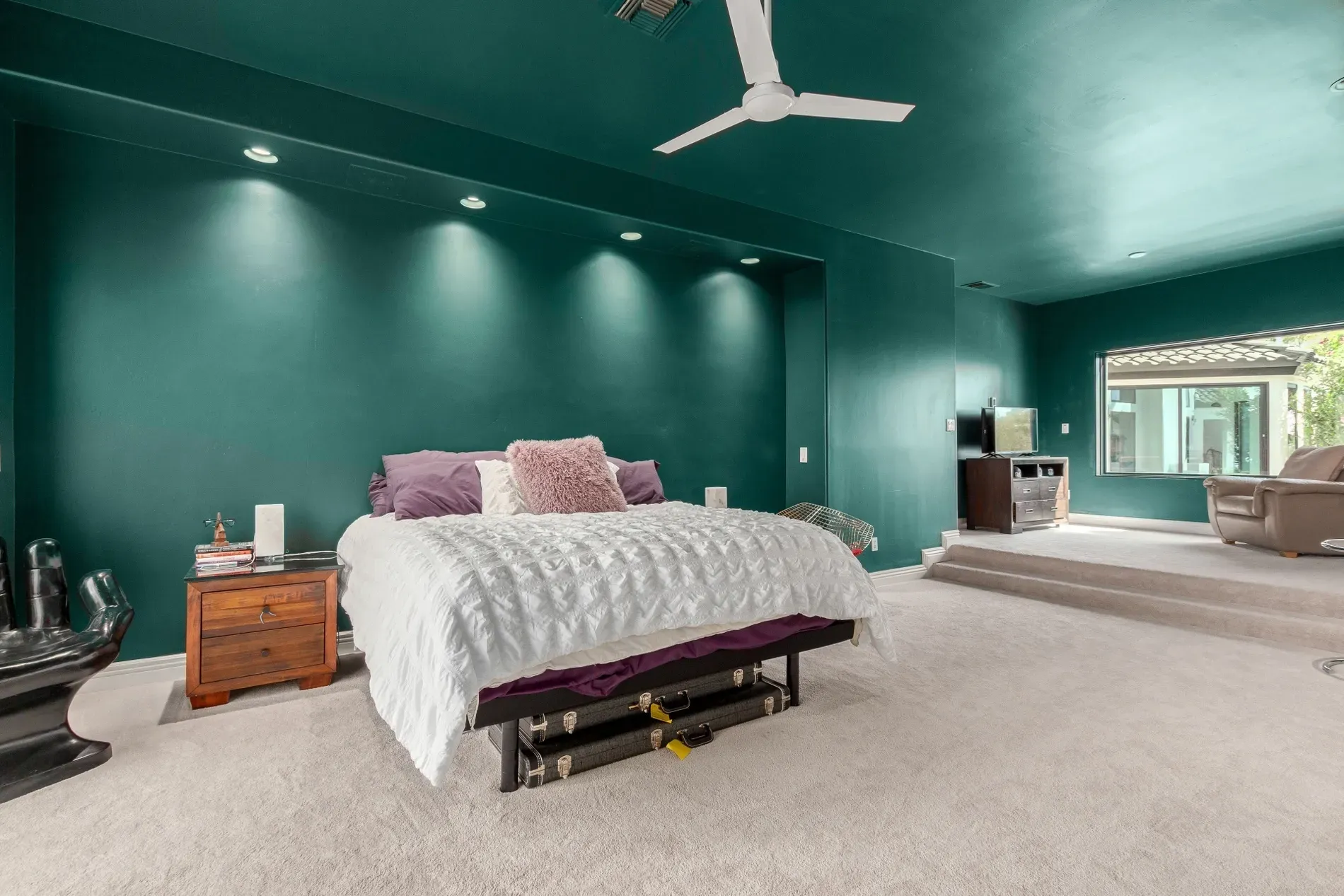 Teal walls go bold. Gray carpet softens it. Not sure about the combo.
